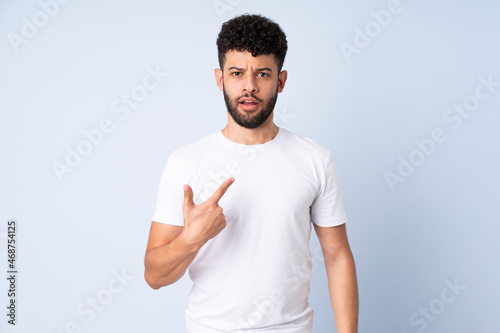 Young Moroccan man isolated on blue background pointing to oneself