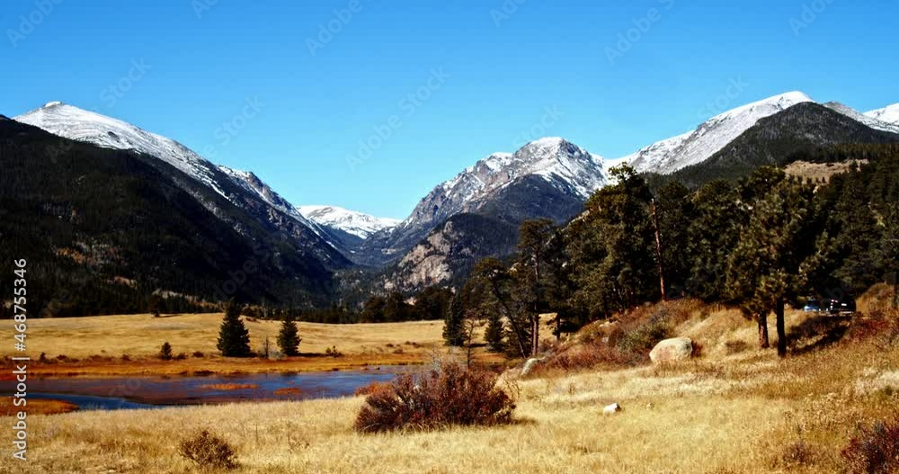 Beautiful colorful valley with a clear alpine pond with snowy mountains in the background. Beautiful colorful valley with a clear alpine pond with snowy mountains in the background.
