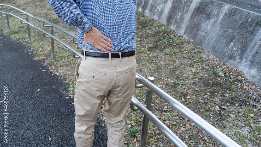 腰痛の男性。スロープの手摺。 腰痛の男性。スロープの手摺。