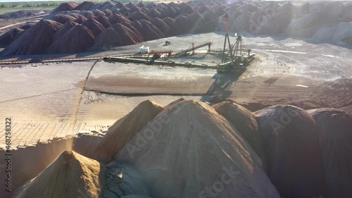 Aerial view of a conveyor in salt pits, mining of potash and salt, conveyor line in working process, salt quarries. Telestacker handles the ore close up for potash waste heaps. High quality 4k footage photo