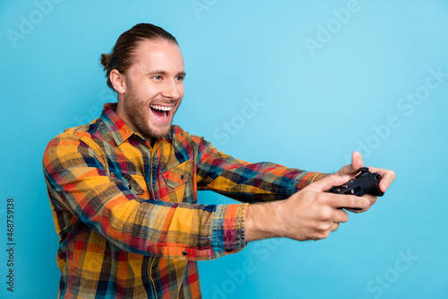 Photo of cool millennial tail hairstyle guy playstation look empty space wear plaid shirt isolated on blue color background