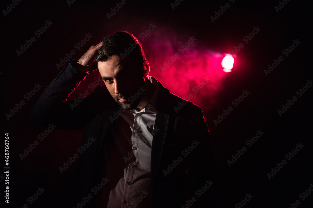 Photo of standing man and pink light on the background. Photo of standing man and pink light on the background.