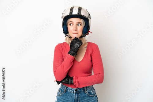 Young caucasian woman with a motorcycle helmet isolated on white background having doubts and thinking © luismolinero