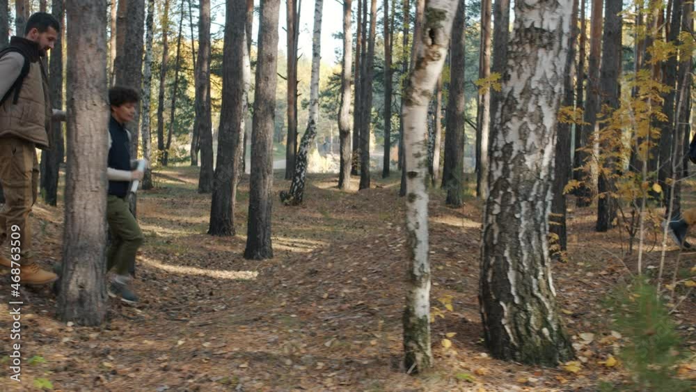 Man and woman tourists walking in forest with child doing high-five enjoying getaway together. Active lifestyle and healthy youth concept. Man and woman tourists walking in forest with child doing high-five enjoying getaway together. Active lifestyle and healthy youth concept.
