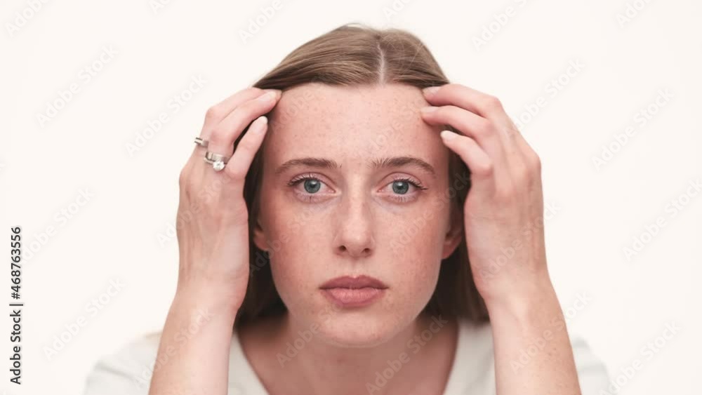 Portrait of happy woman correcting her face at the camera in white studio Portrait of happy woman correcting her face at the camera in white studio