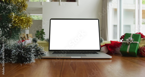 Wallpaper Mural Laptop with copy space on screen on table with santa hats, decorated christmas tree and presents Torontodigital.ca