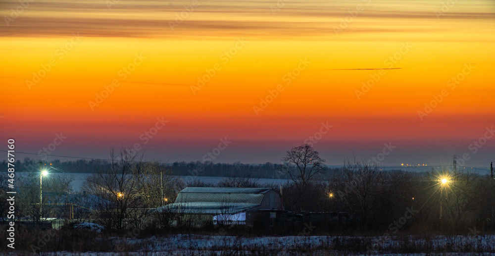 sunset over the village . Winter sunset 