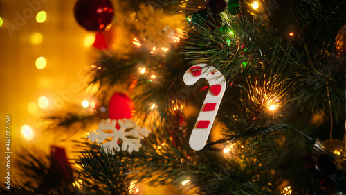 Closeup of colorful Chrsitmas ree garland lights, baubles and toys hanging on Christmas tree. photo