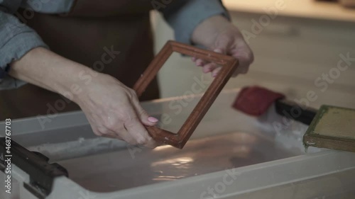 A woman holding a frame for making paper sheets from recycled paper. Selective focus. Household hobby, paper recycling. The concept of zero waste, recycling, ecology