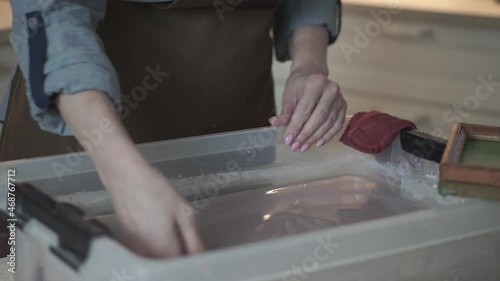 A woman holding a frame for making paper sheets from recycled paper. Selective focus. Household hobby, paper recycling. The concept of zero waste, recycling, ecology