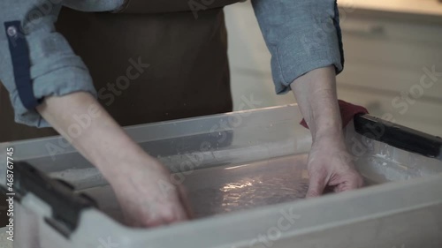 A woman holding a frame for making paper sheets from recycled paper. Selective focus. Household hobby, paper recycling. The concept of zero waste, recycling, ecology