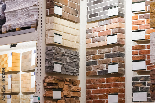 Exhibition showing samples of decorative stone tiles of different colors on the shelves of the store's warehouse.