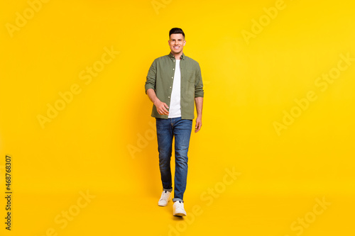 Full length body size photo guy walking forward isolated vibrant yellow color background
