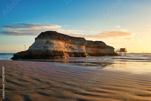 Sunset at beach and rocky island on Gironde estuary coast near Royan, Charente Maritime, France