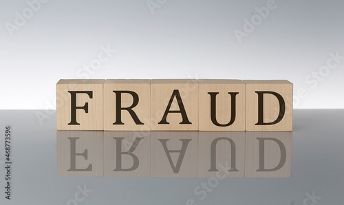 FRAUD word made with building blocks isolated on grey background
