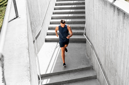 fitness, sport and healthy lifestyle concept - young man running downstairs
