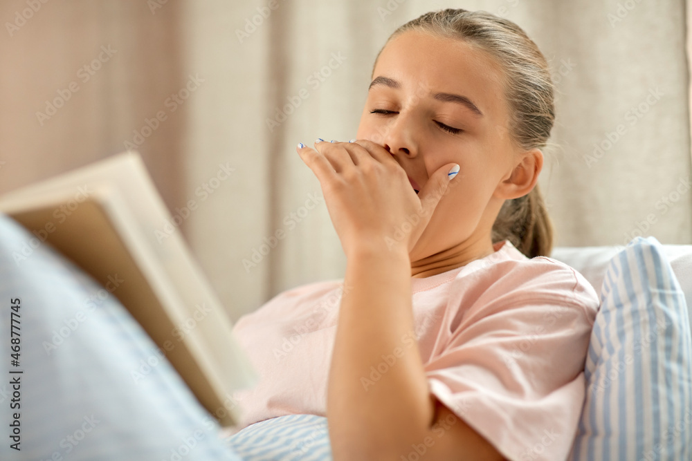 people, bedtime and sleeping concept - yawning girl reading book in bed at home people, bedtime and sleeping concept - yawning girl reading book in bed at home