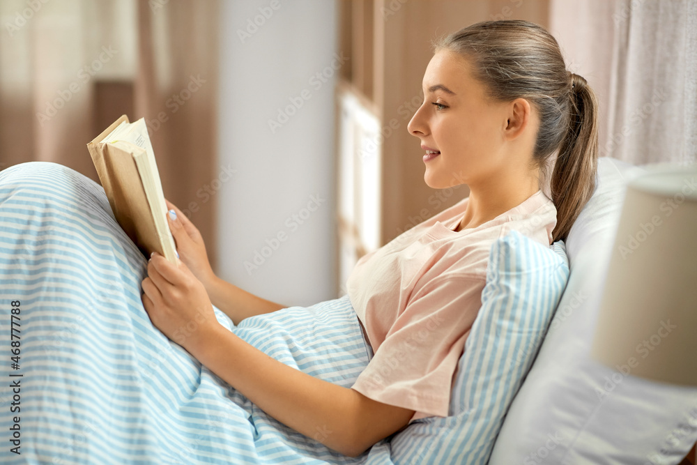people, bedtime and sleeping concept - smiling girl reading book in bed at home people, bedtime and sleeping concept - smiling girl reading book in bed at home