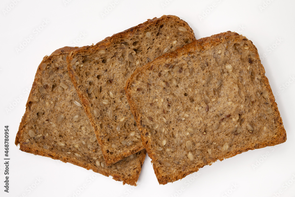 Three slices of wholegrain bread with seeds of sunflower, flax, and sesame. Healthy vegetarian food. Isolated flatlay. Three slices of wholegrain bread with seeds of sunflower, flax, and sesame. Healthy vegetarian food. Isolated flatlay.