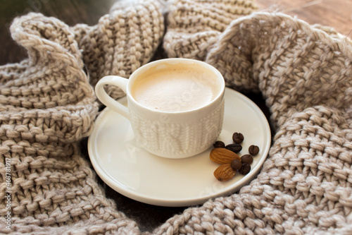 Cup of coffee in a beige scarf