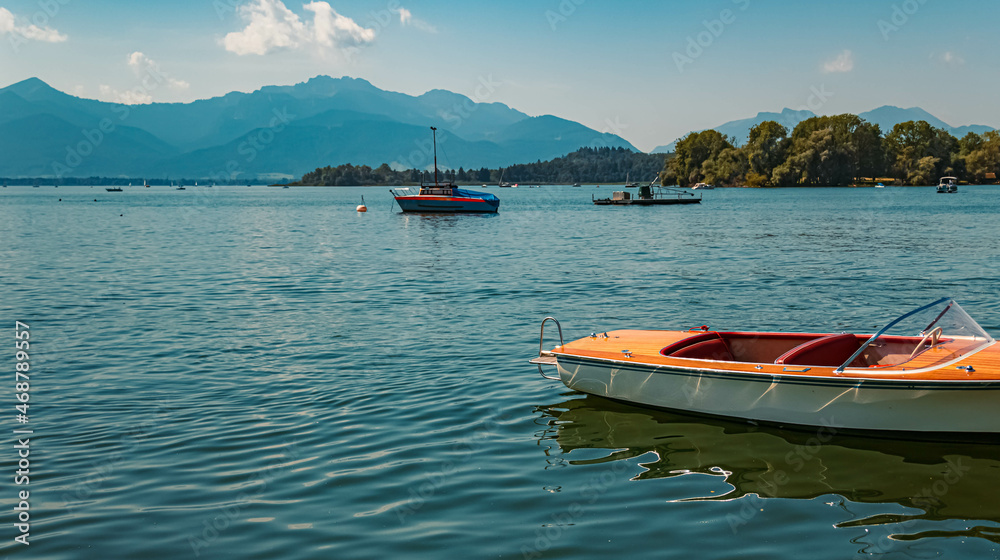 Beautiful alpine summer view with a small wooden boat at the famous Chiemsee, Bavaria, Germany