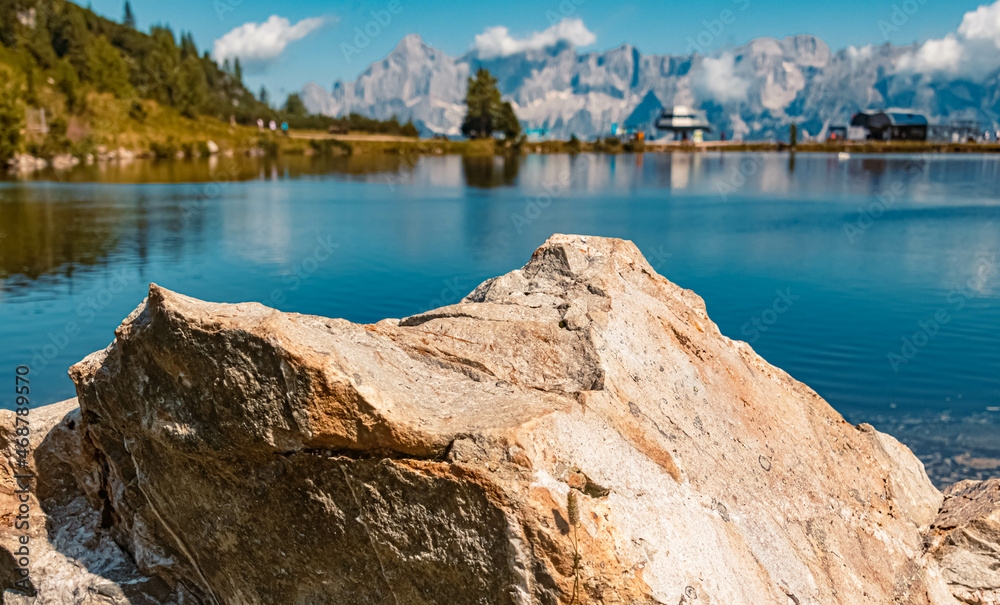 Beautiful alpine summer view with details of a rock and the famous Dachstein mountains in the background at the Reiteralm, Pichl, Schladming, Steiermark, Austria