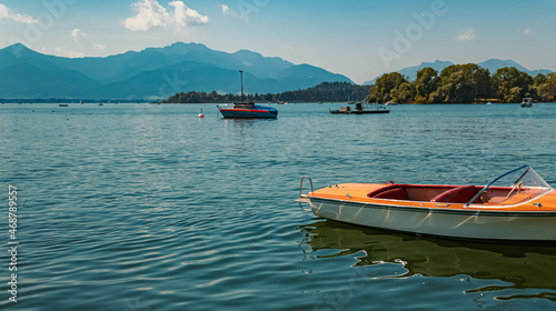 Beautiful alpine summer view with a small wooden boat at the famous Chiemsee, Bavaria, Germany