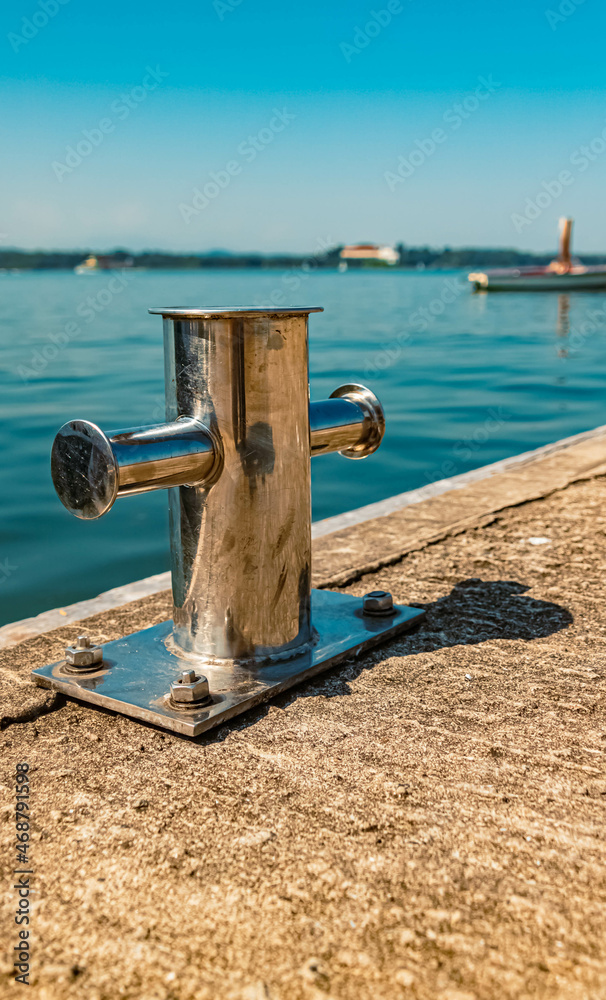 Fototapeta premium Details of chrome-plated boat mounting post in summer with reflections at the famous Chiemsee, Bavaria, Germany