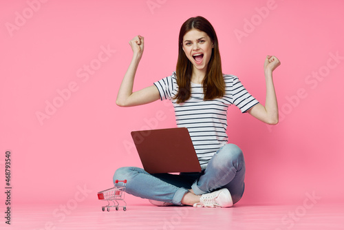 woman with laptop on pink background online shopping entertainment