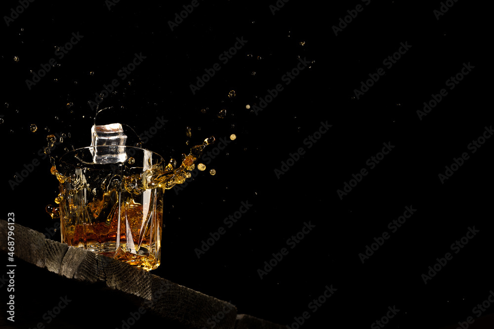 whiskey in a glass on a black background on a wooden table whiskey in a glass on a black background on a wooden table