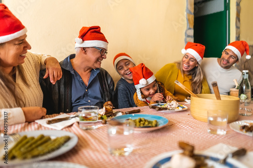 Happy Latin family dining together while celebrating Christmas holidays at home