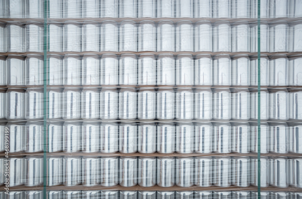 Aluminum cans for drinks stacked on shelf in warehouse. New unused aluminium for cold beverages Aluminum cans for drinks stacked on shelf in warehouse. New unused aluminium for cold beverages