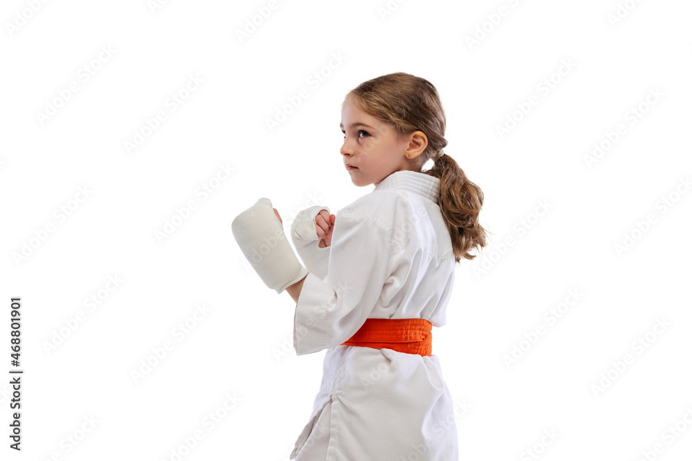 One little girl, young karate in kimono practicing isolated over white background. Concept of sport, education, skills One little girl, young karate in kimono practicing isolated over white background. Concept of sport, education, skills