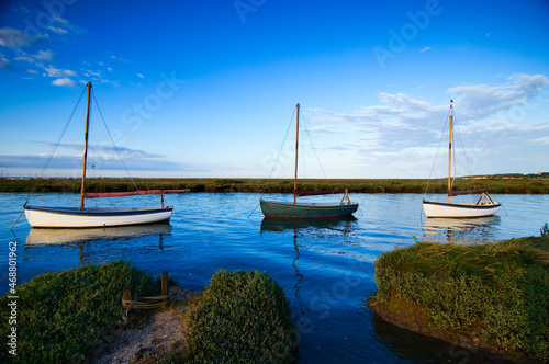 Three small sailing boats at Morston Quay, Morston Marshes, North Norfolk Coast, England, UK. photo