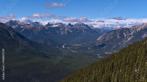 Rugged Rocky Mountains (Massive Range) with snow-capped peaks above Bow Valley with winding river and Trans-Canada Highway near Banff, Canada.
