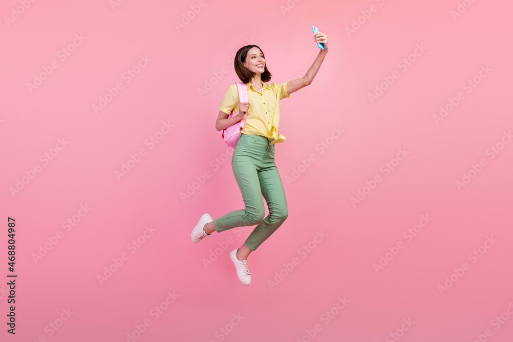 Full body profile side photo of young girl happy smile make selfie smartphone jump isolated over pink color background