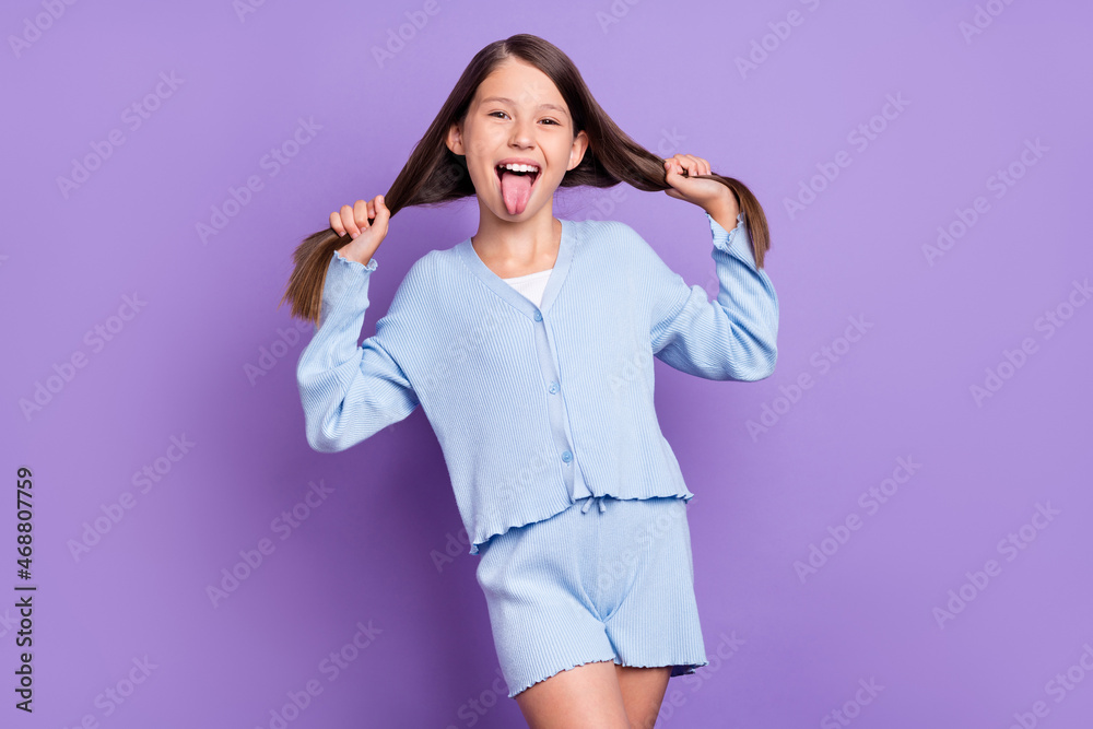 Photo of impressed brunette small girl tongue out wear blue shirt shorts isolated on violet color background Photo of impressed brunette small girl tongue out wear blue shirt shorts isolated on violet color background