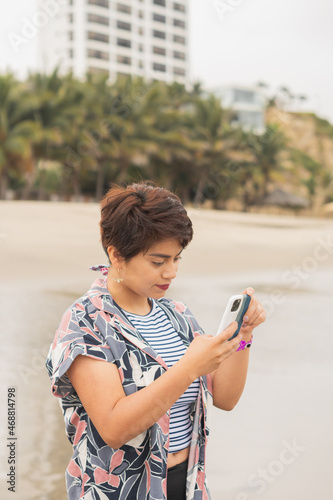 Young woman taking pictures of the beach.