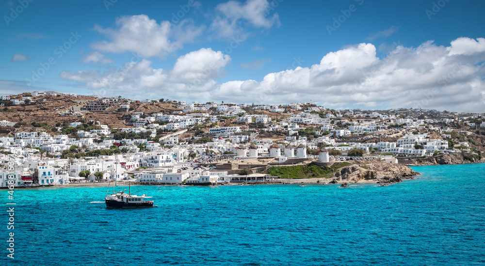 Panoramic landscape with town and windmills along coastline on Mykonos Island, Greece.