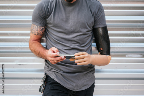 Anonymous content man with prosthetic arm using cellphone photo