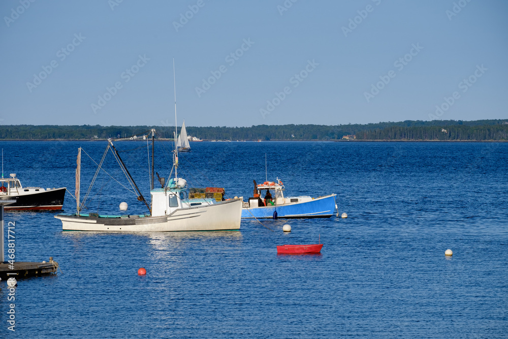 Obraz premium Anchored colorful red white and blue Lobster Boats on a perfect summer day sitting at harbor