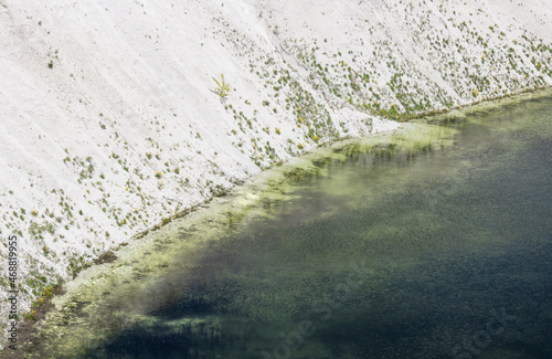 clear water in a chalk quarry with a grassy steep bank