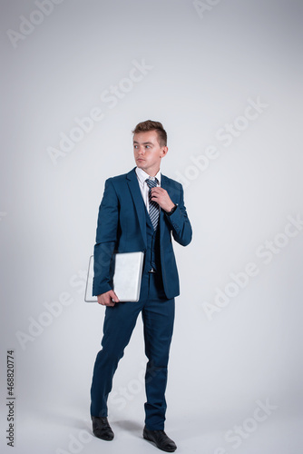 Fotografi Handsome man in a business suit with a laptop in his hands