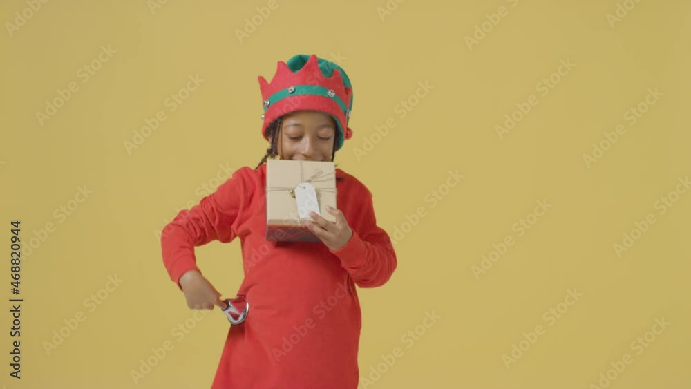 Smiling Boy Ringing Bell and Holding Christmas Present Smiling Boy Ringing Bell and Holding Christmas Present