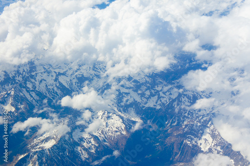 Flying over the mountains with clouds, top view