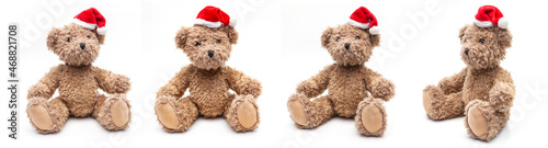 Vier Teddybären mit Weihnachtsmütze sitzend auf weißem Hintergrund photo