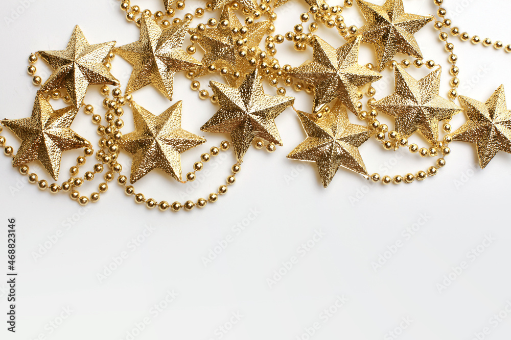 Gold star and bead garland on white backgroun. Flat lay.  Top view.