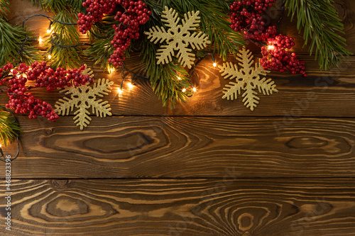 Wallpaper Mural Christmas background. Nobilis fir branches, twigs with red berries, toy golden snowflakes on brown wooden planks. Copy space, flat lay, top view. Holiday, Xmas, New Year concept. Mockup Torontodigital.ca