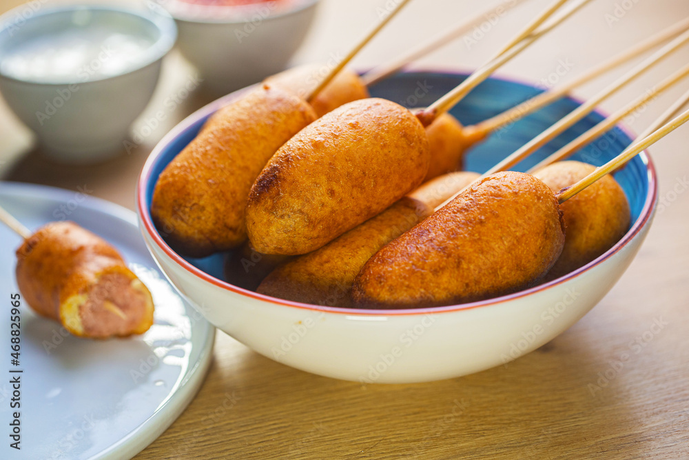 Corn dogs cooked with sausage and dough on a blue plate - obrazy, fototapety, plakaty 