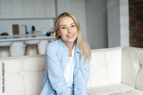 Happy young woman looking at camera, smiling wide